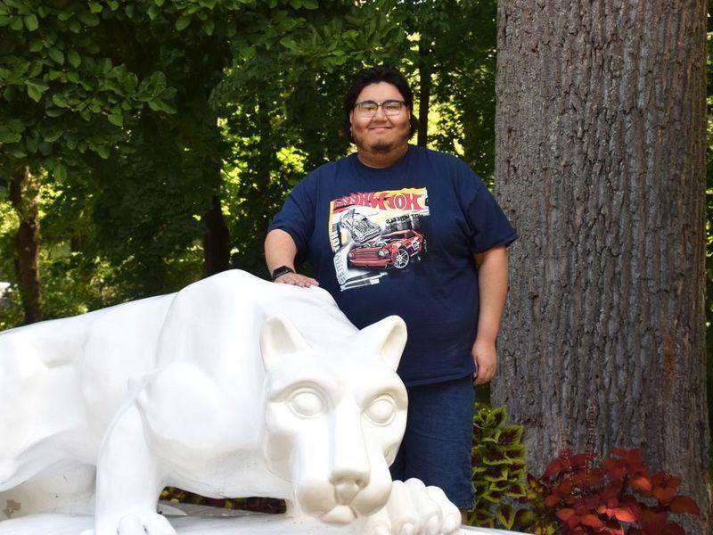 Man standing behind lion statue